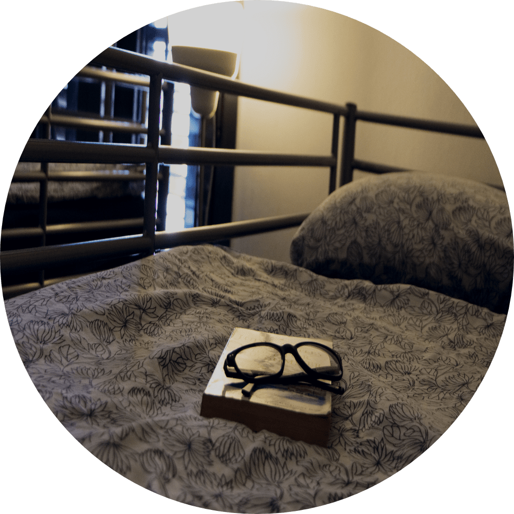 book and glasses on bed